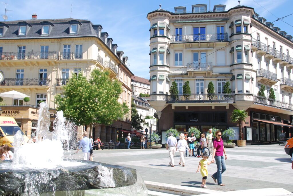 Leopoldsplatz in Baden Baden mit Springbrunnen und Passanten,