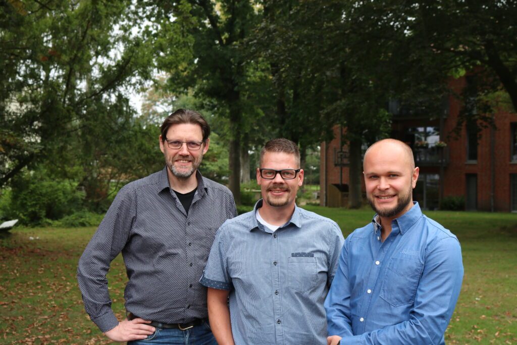 Drei Personen von der IT Abteilung bei Friedehorst im Garten, von links nach rechts Herr Krause, Herr Grehl und Herr Wantje.