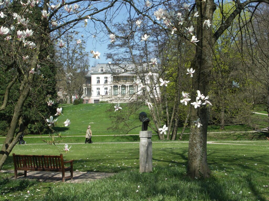 Die Lichtentaler-Allee in Baden Baden mit blühenden Bäumen und saftig grünem Gras.