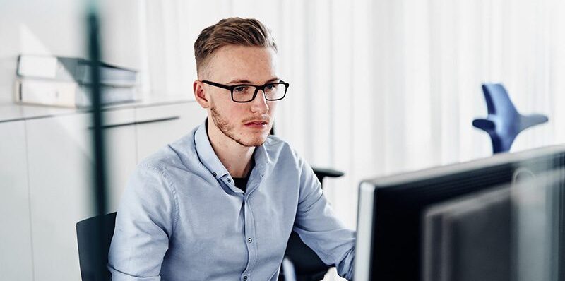 Männlicher Rena-Mitarbeiter bei der Arbeit am Computer.