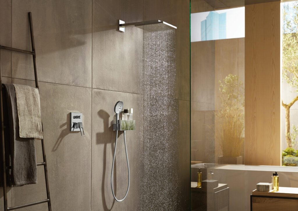 Eine Dusche mit einer großen Kopfbrauseder Firma hansgrohe, aus der Wasser strömt.