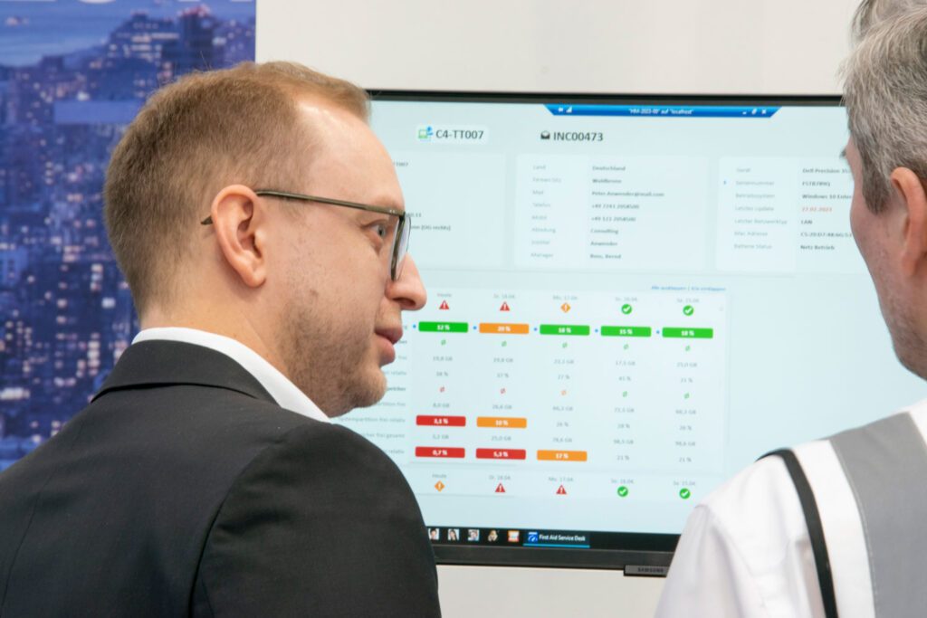 Der Leiter des Produktmanagements Carlos Kohl zeigt einem Interessenten das Produkt F4SD auf einem Bildschirm.
