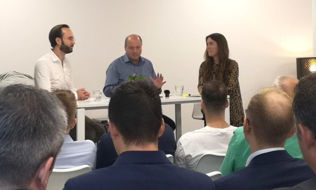 Patrick Hild, Christian Müller und Sandra Frick unterhalten sich an einem weißen Hochtisch.