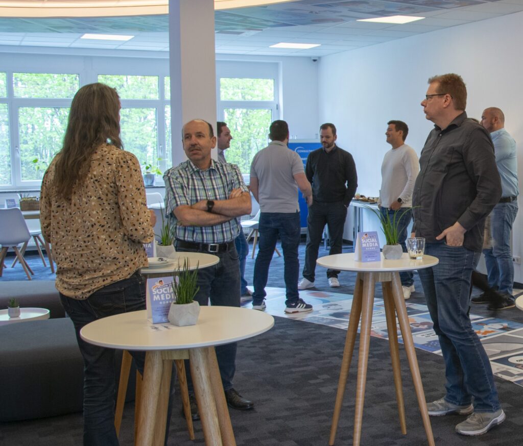 Mehrere Teilnehmer der Schulung "Nexthink Expert Series" unterhalten sich in der Kaffeepause miteinander.