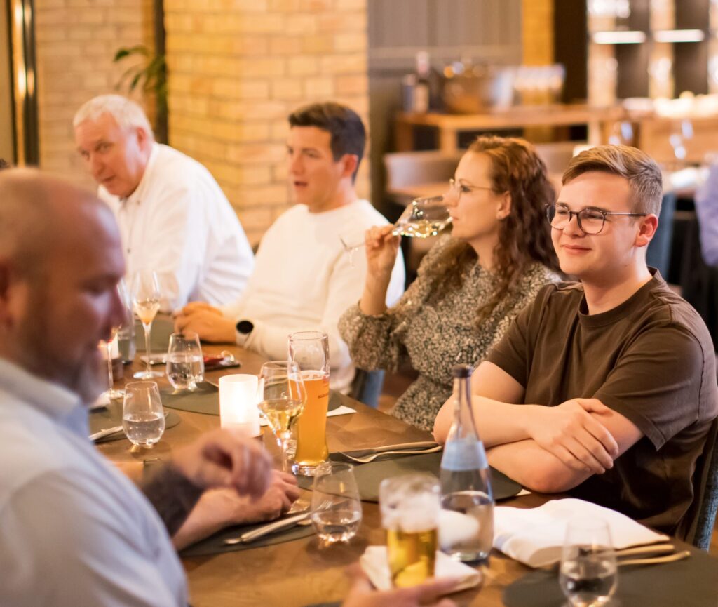 Schulungsteilnehmer der Consulting4IT-Academy sitzen mit Getränken am Tisch im Fine Dining Restaurant Kesselhaus.