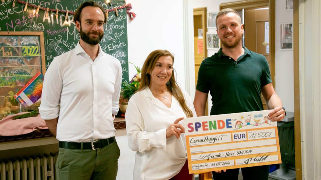 Consulting4IT Geschäftsführer Patrick Hild und Consultant Raik Vogt übergeben einen Spendenschein in Höhe von 12500 Euro an Frau Sahin vom Lernfreunde-Haus Uneson.
