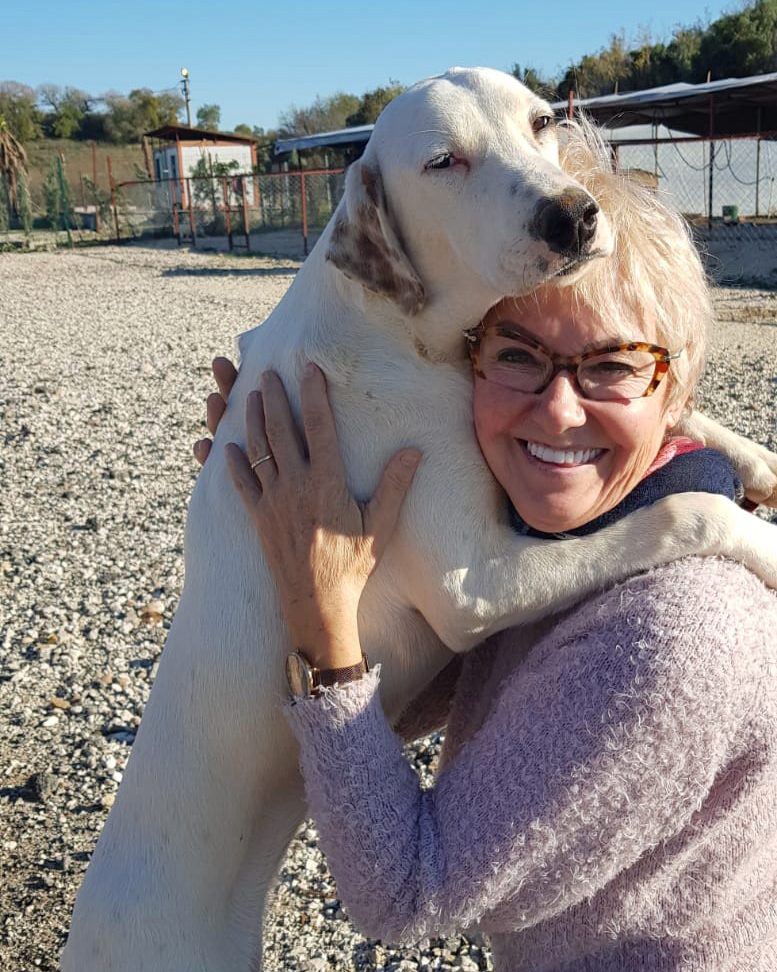 Barbara Schellenberg, die von einem weißen Hund umarmt wird im Tierheim in der Türkei.