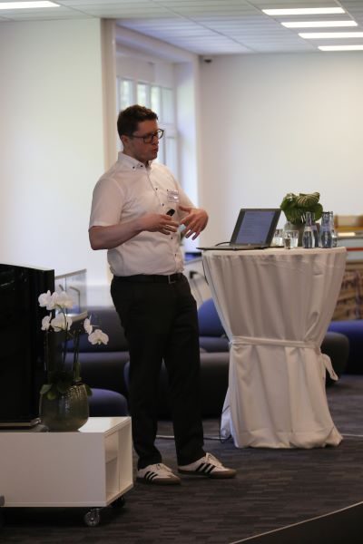 Ansicht eines Mannes auf der Bühne in der Consulting4IT Academy, der gerade vorträgt.