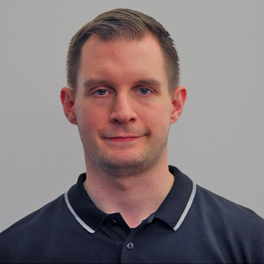 Porträt eines jungen Mannes im Polo-Shirt mit kurzen Haaren.
