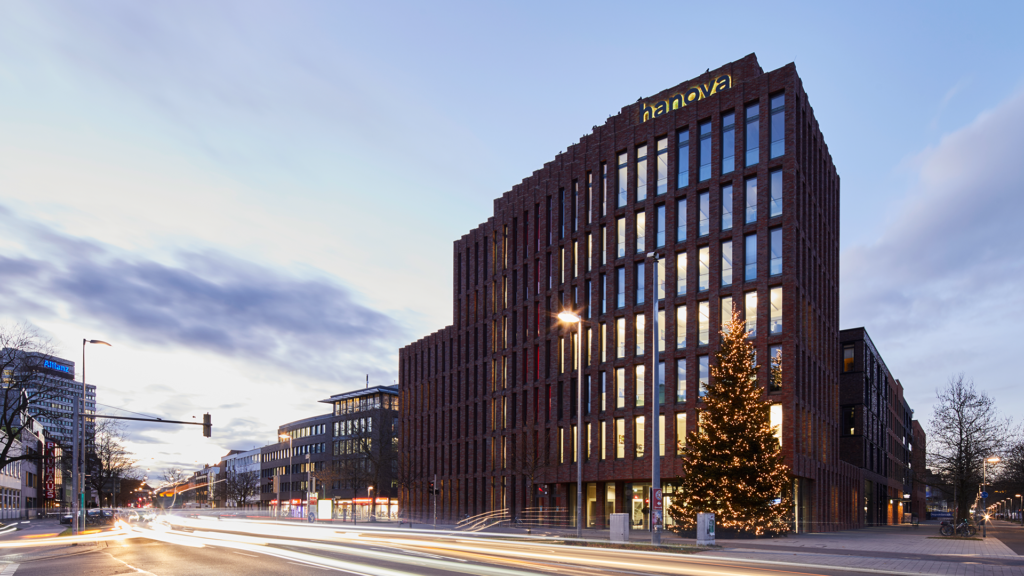 Das Firmengebäude von hanova bei Abenddämmerung mit geschmücktem Weihnachtsbaum.